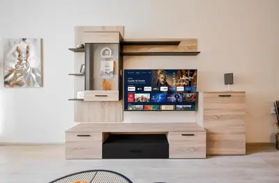 a living room with a flat screen tv on a wooden entertainment center at Orchidea City Centre 1BDR by Flat Mаnager in Sofia