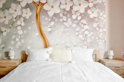a bedroom with a bed with white flowers on the wall at Orchidea City Centre 1BDR by Flat Mаnager in Sofia