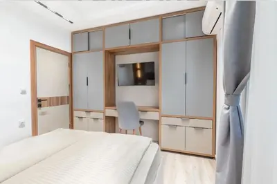 a bedroom with a white bed and a desk at Апартхотел Сенатор Пловдив Self check-in in Plovdiv
