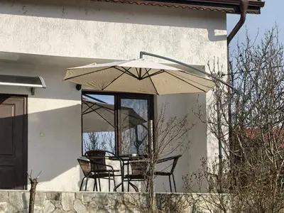 a patio with a table and chairs under an umbrella at Харизма in Hisarya