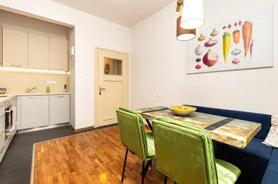 a kitchen and dining room with a table and green chairs at HeBrOs Park Apartment Next to Kapana 2BR in Plovdiv