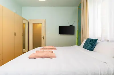 a bedroom with a white bed with towels on it at HeBrOs Park Apartment Next to Kapana 2BR in Plovdiv