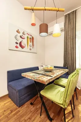 a dining room with a table and a blue couch at HeBrOs Park Apartment Next to Kapana 2BR in Plovdiv