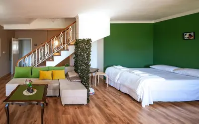 a bedroom with green walls and a bed and a staircase at 2BDR Yavorov apartment in Sofia