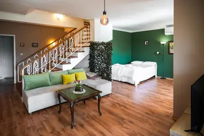 a living room with a couch and a staircase at 2BDR Yavorov apartment in Sofia