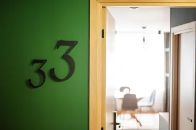 a number on a green wall next to a door at Уютно Студио Verde Suites 33 in Blagoevgrad