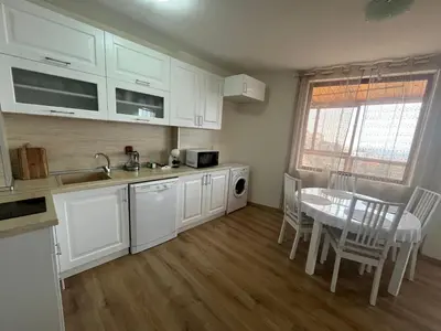 a kitchen with white cabinets and a table and a dining room at BELLA VISTA Holiday Home 24h check in in Sandanski