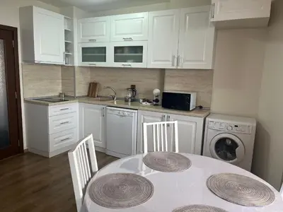 a kitchen with a table and a sink and a dishwasher at BELLA VISTA Holiday Home 24h check in in Sandanski
