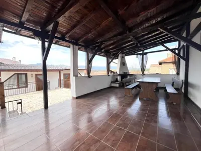 a large room with a table and benches in it at Апартаменти село Баня in Banya