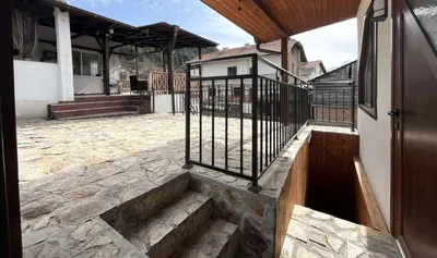 a stairway leading to a building with a gate at Апартаменти село Баня in Banya