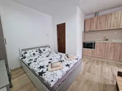 a bedroom with a large bed in a kitchen at Апартаменти село Баня in Banya