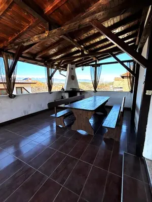 a large wooden table in a room with a view at Апартаменти село Баня in Banya