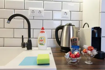 a kitchen counter top with a sink with a mixer and a sink at Smart Studio in the heart of Sofia in Sofia