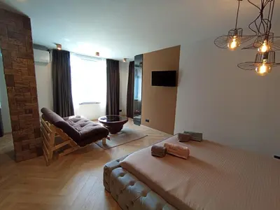 a bedroom with a bed and a couch and a chair at Уютно Студио Verde Suites 07 in Blagoevgrad