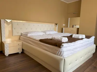 a bedroom with a large white bed with a wooden floor at ApartmentSpiceDevin in Devin