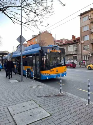 a blue and yellow bus parked at a bus stop at Slavveykovs Apartment in Sofia