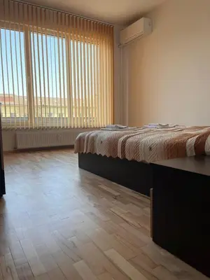 a large room with a bed and large windows at Slavveykovs Apartment in Sofia