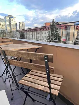 a row of wooden tables and benches on a balcony at Slavveykovs Apartment in Sofia