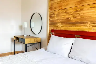 a bedroom with a bed with a wooden headboard and a mirror at 'Chamonix' in Bansko - 1 bedroom - SKI IN&OUT - Free spa in Bansko