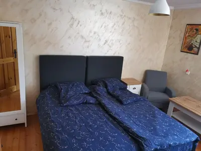 a bed with a blue comforter in a bedroom at Къща Томови in Devin
