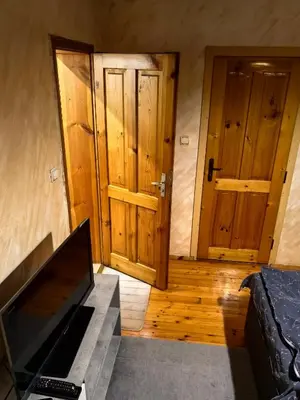 a room with two wooden doors and a television at Къща Томови in Devin