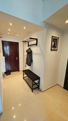 a hallway with a staircase with a bench next to a door at Central Springs Apartment in Sofia