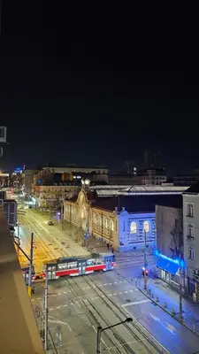 a city at night with a train on the tracks at Central Springs Apartment in Sofia