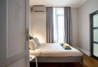a small bedroom with a bed and a window at Landmark Luxe 2BR Apt with Parking in Sofia