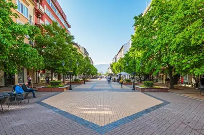 an empty street with trees and people sitting on benches at Casa Dolce far niente , in Blue, PARKING in Sofia