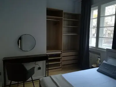 a bedroom with a bed and a mirror and a chair at Urban Comfort - Central 1BDR near Vitoshka & NDK by Flat Mаnager in Sofia