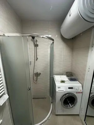 a bathroom with a shower and a washing machine at Apartment Aria 4 in Velingrad