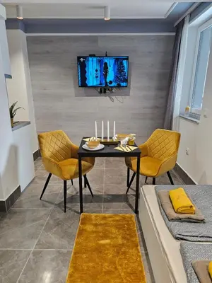 a dining room with a table and chairs and a tv at Continental studios 1 in Sofia