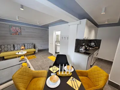 a living room with a table and yellow chairs at Continental studios 1 in Sofia