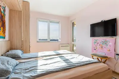 a bedroom with a bed and a flat screen tv at Apart Center Nikola in Plovdiv