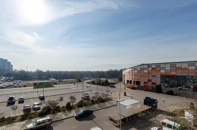 a view of a parking lot with a building and cars at Apart Center Nikola in Plovdiv