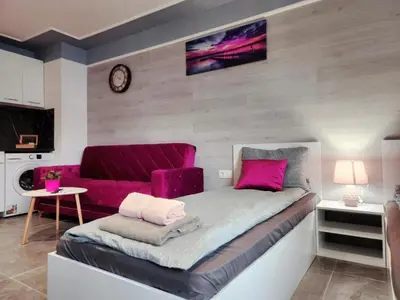 a bedroom with a purple bed and a couch at Continental studios 3 in Sofia