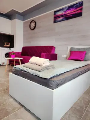 a bed in a room with a purple couch at Continental studios 3 in Sofia