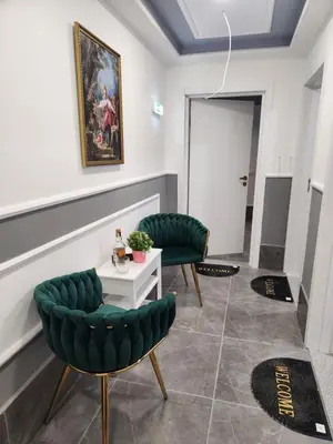 a living room with two green chairs and a table at Continental studios 2 in Sofia