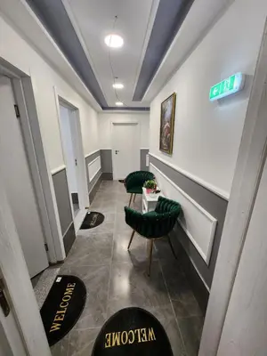 a hallway with two green chairs and a sign on the wall at Continental studios 2 in Sofia