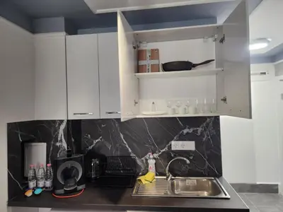 a kitchen with white cabinets and a sink at Continental studios 2 in Sofia