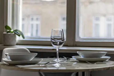 a table with a wine glass and plates on it at Grand Suborna Retreat in Sofia