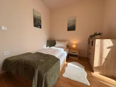 a bedroom with a bed and a dresser at Apart-Tundzha 6 in Sofia