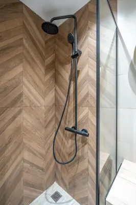 a shower with a shower head on a wooden wall at Elegant & Stylish 2-Bedroom Apartment in Sofia