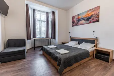 a bedroom with a bed and a chair in it at Vitoshka Inn - R1 in Sofia