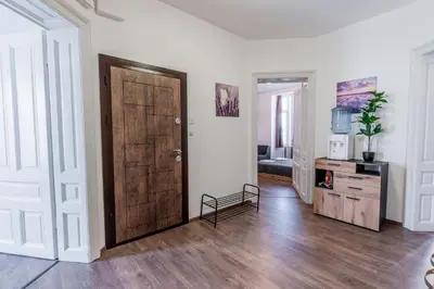 a room with a wooden door and a living room at Vitoshka Inn - R1 in Sofia