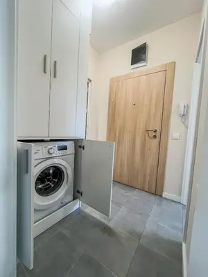 a kitchen with a washing machine and a wooden door at Scandi Suite Business & Leisure in Sofia