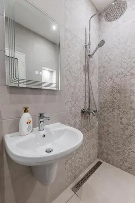 a bathroom with a sink and a shower with a mirror at Vitoshka Inn - R2 in Sofia