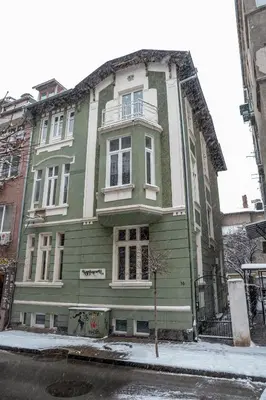 a green and white building on a city street at Vitoshka Inn - R3 in Sofia