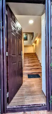 a hallway with a large wooden door and stairs at Vila Nikol Apt #3 in Raduil