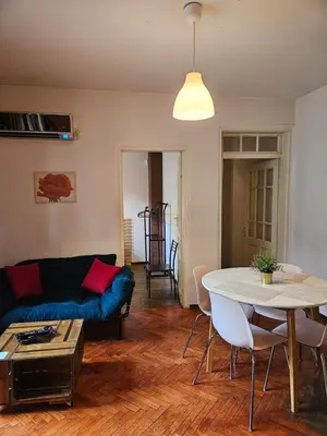 a living room with a blue couch and a table at Hot Spot 2bdrm apartment 1 in Sofia